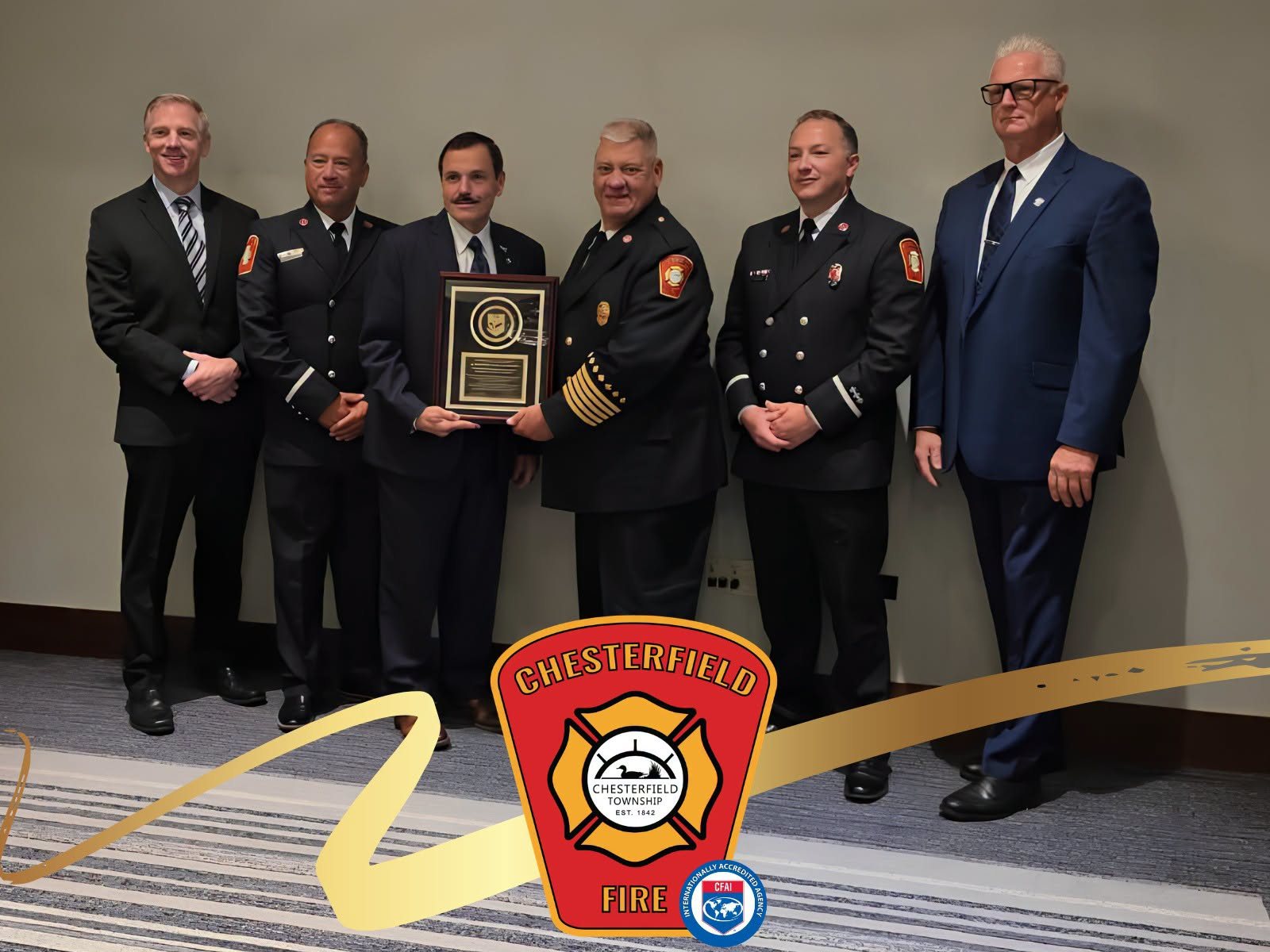 The CFAI accreditation award. From left: Director Brian Bassett, Lt. Jim Schafer Jr., a CFAI representative, Chief Craig Miller, Lt. Steven Rogers and Supervisor Bradley Kersten