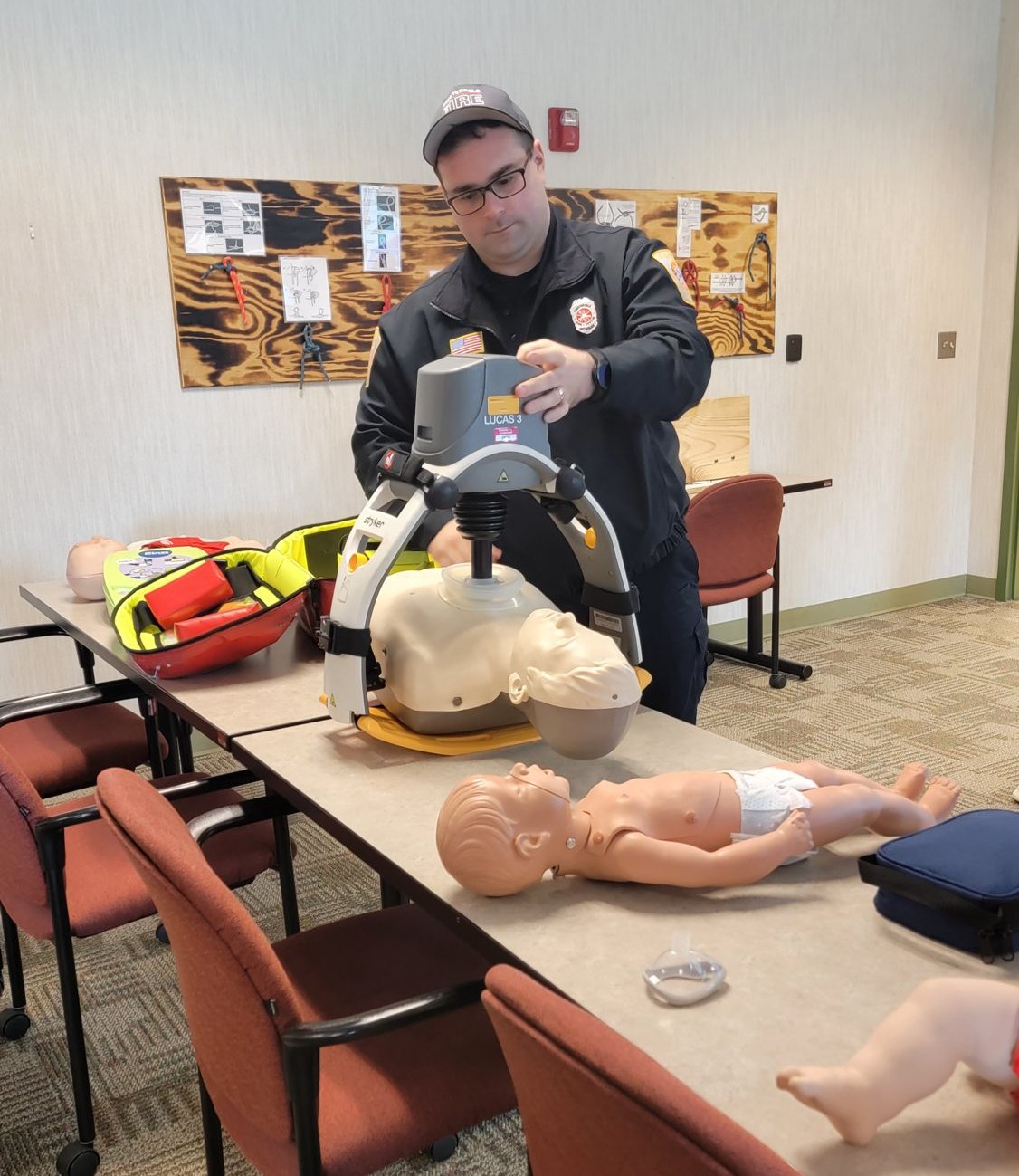 A Chesterfield firefighter demonstrating the LUCAS chest compression device to a CPR class