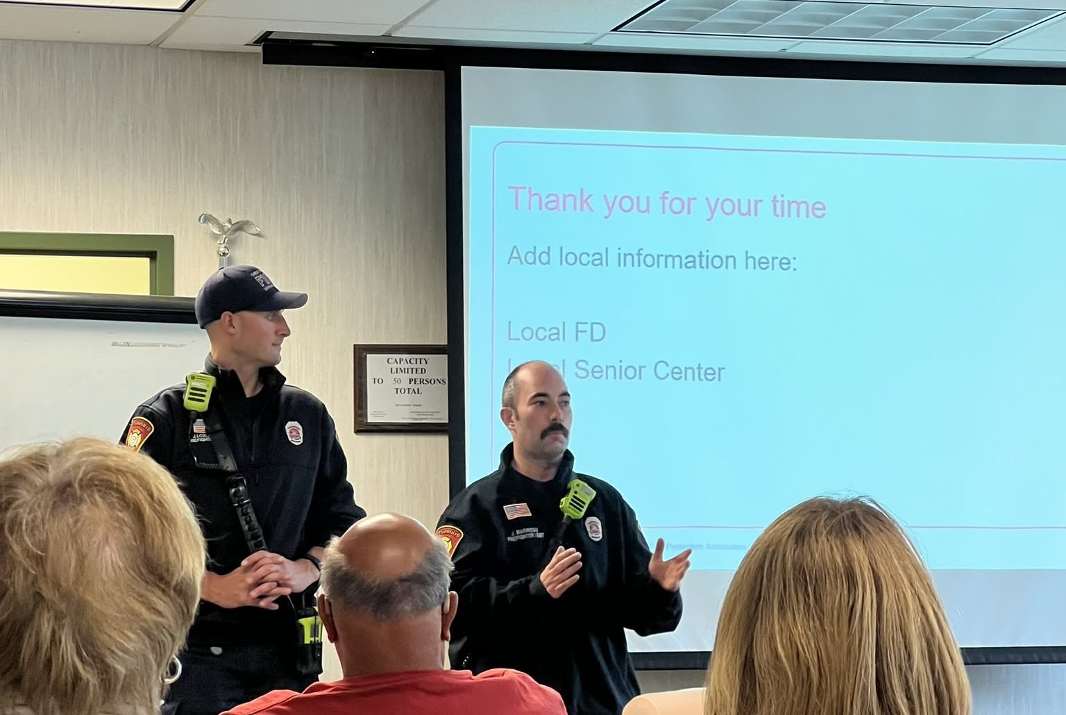 Firefighters presenting fire safety information to a group of residents