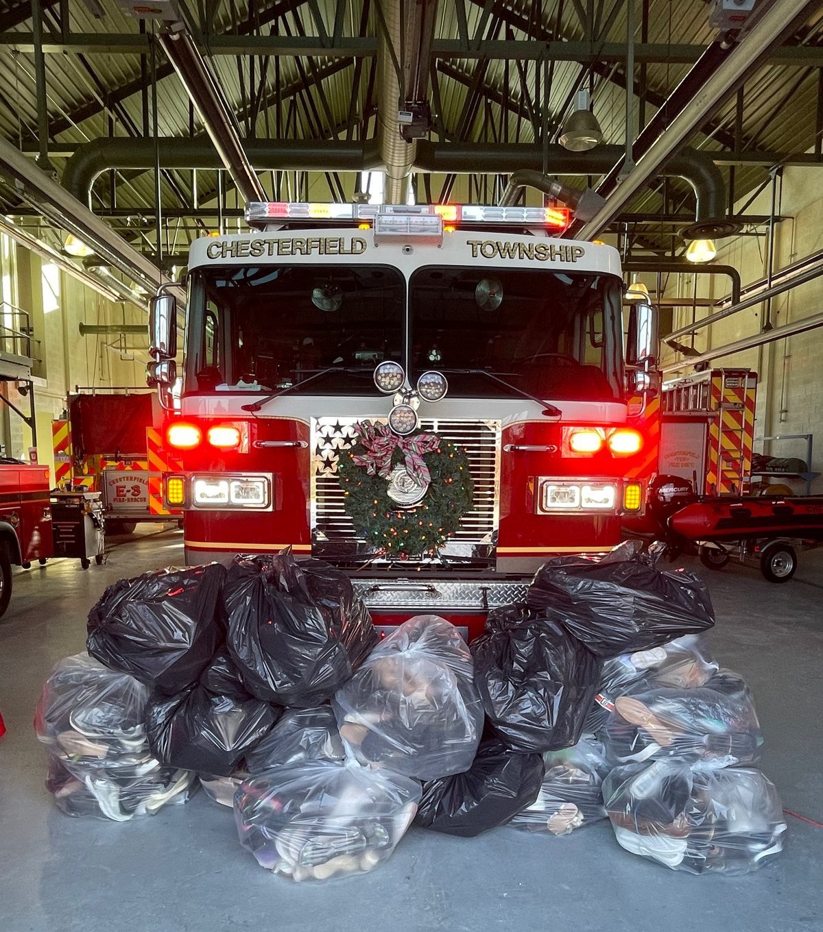 Bags of donated shoes piled in front of an engine at Fire Station 3