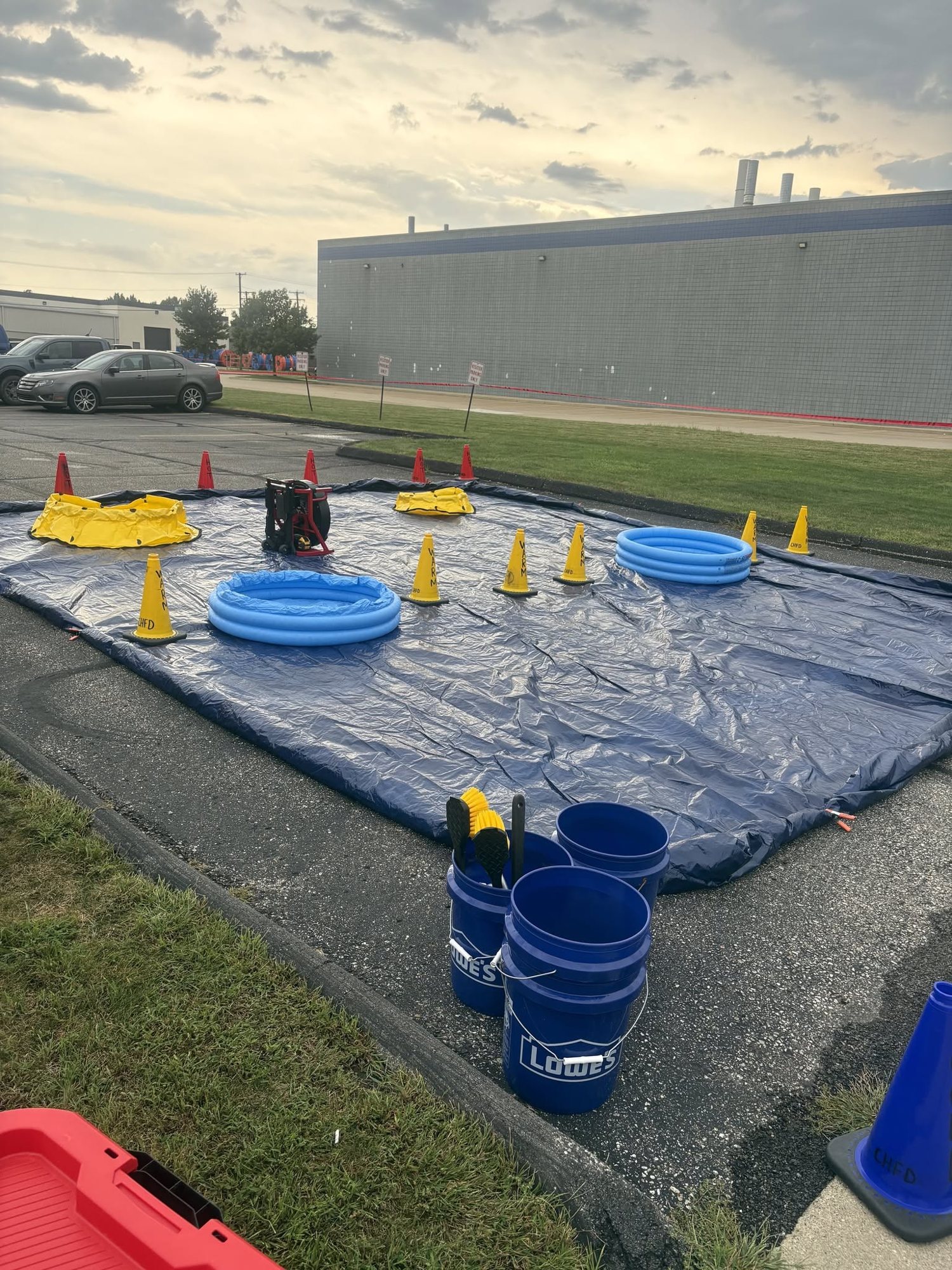 Containment pools, tarps and buckets set out for a hazardous materials drill