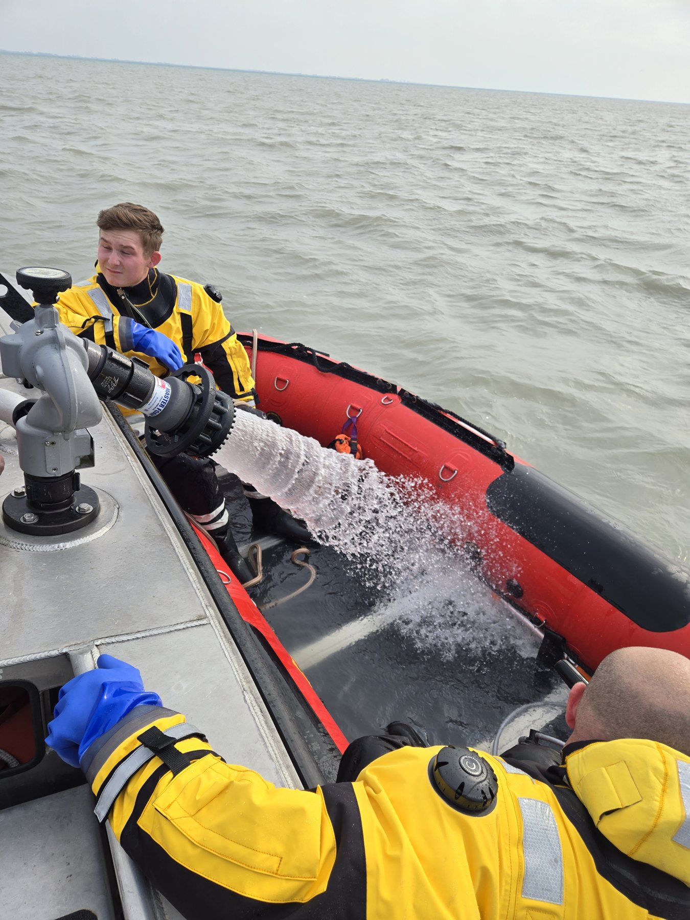 Crews flowing water from the monitor on a rescue boat