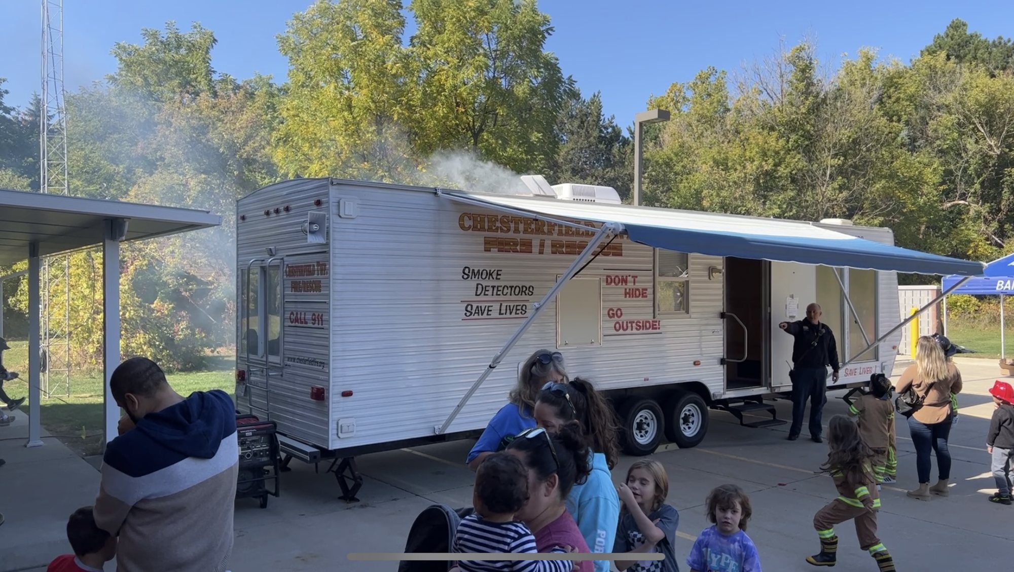Children lining up to tour the fire safety house trailer