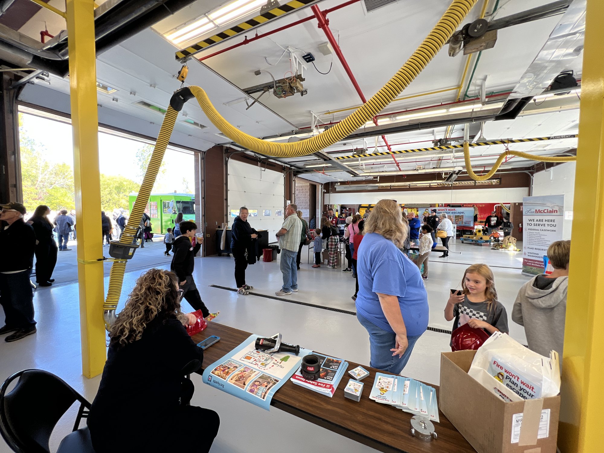 Community tables and booths set up in the apparatus bay