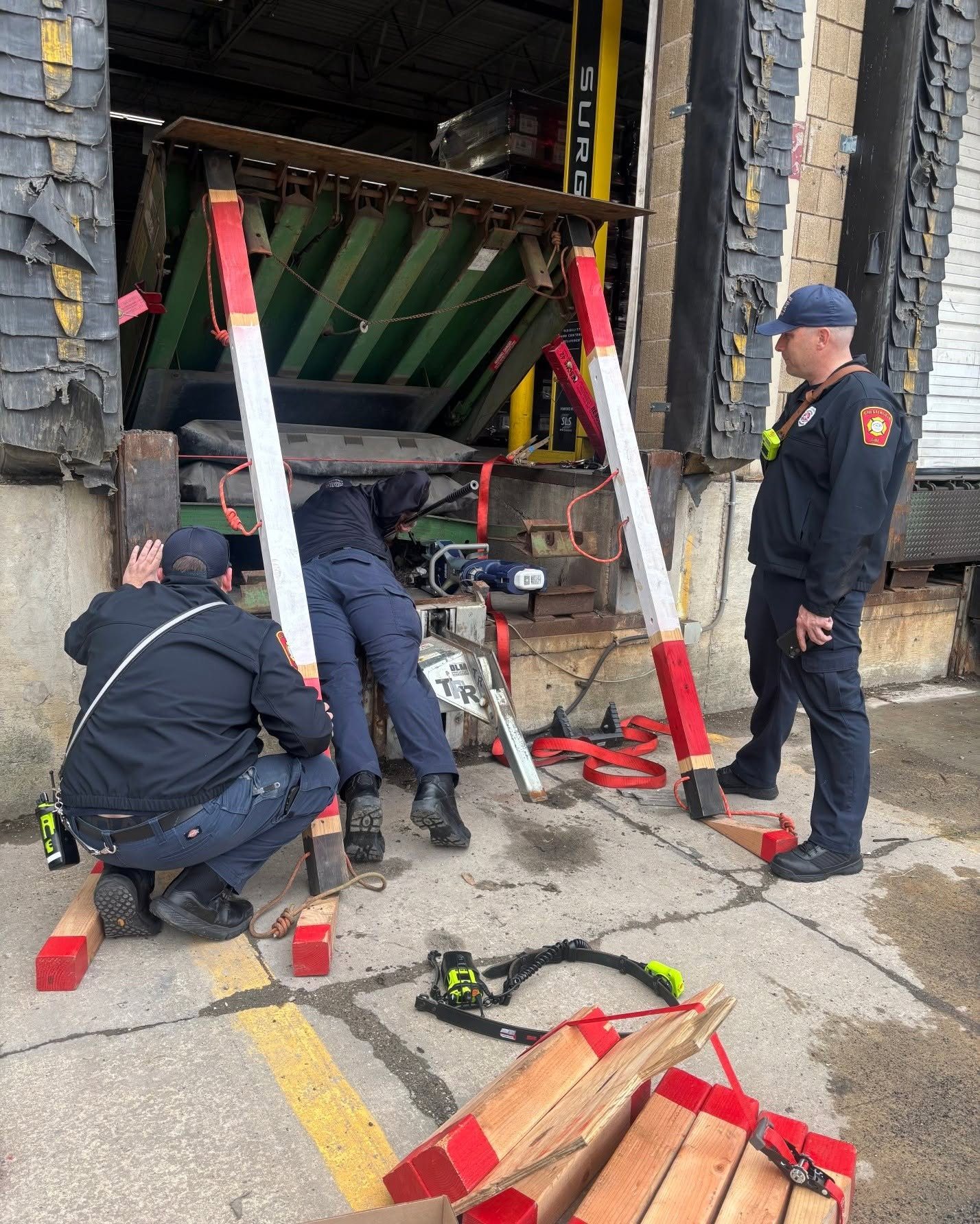 Crews stabilizing a heavy load with rescue struts and cribbing