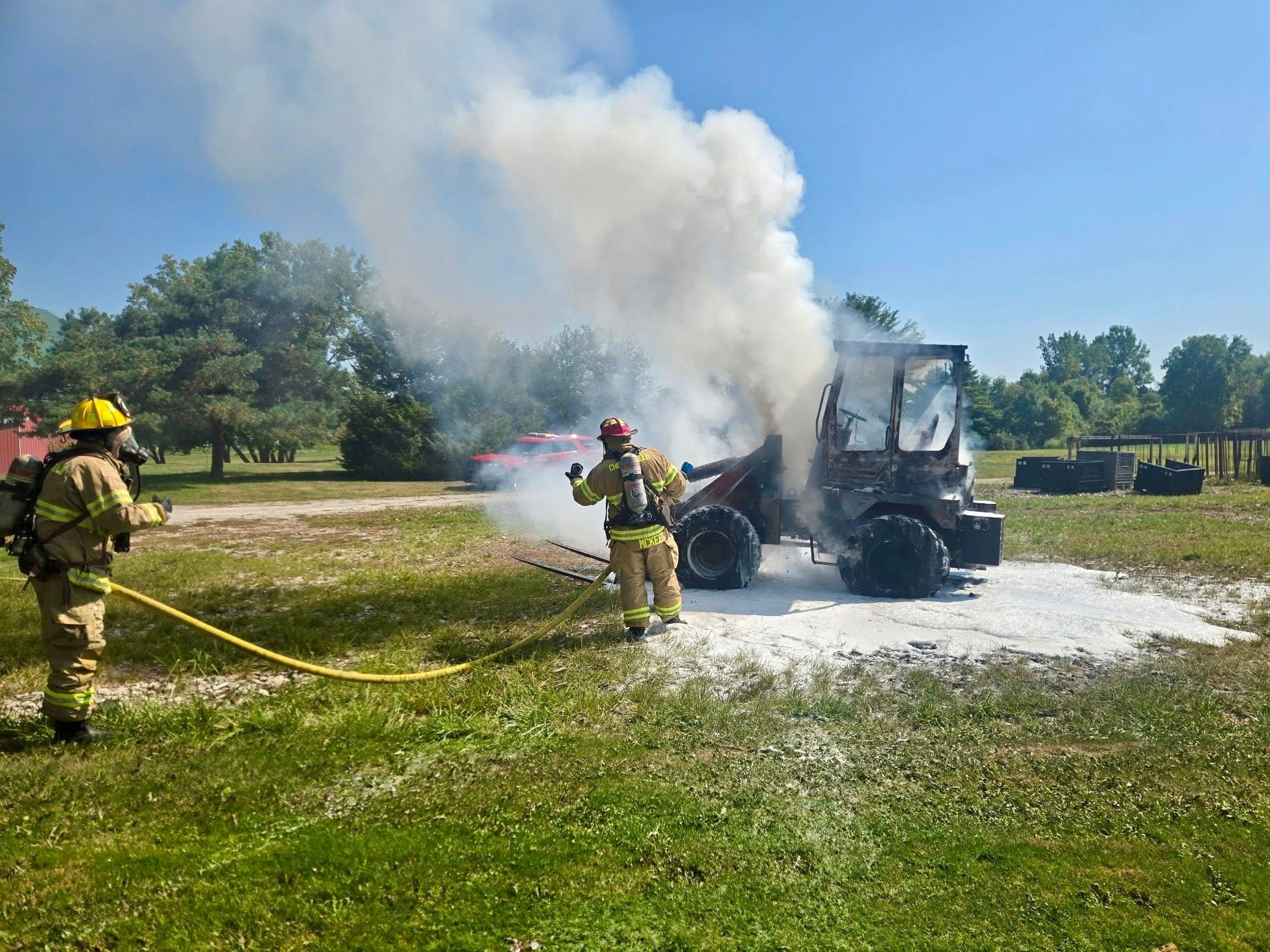 Firefighters extinguishing an equipment fire with foam