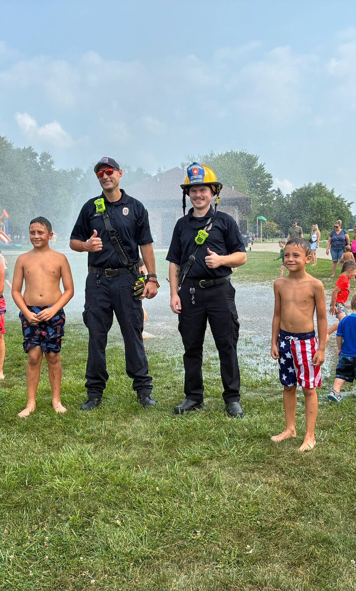Firefighters with children at a summer splash day