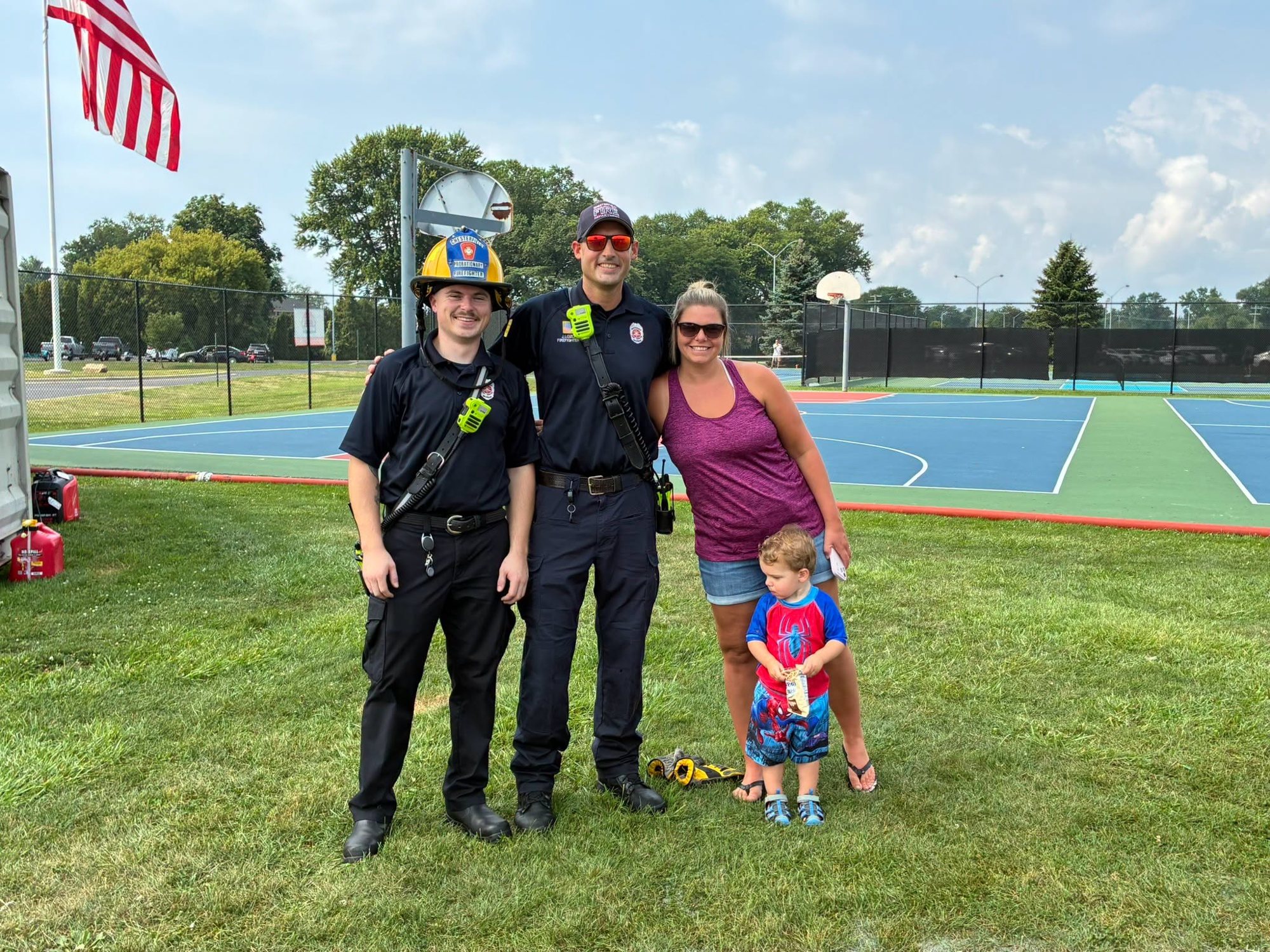 Firefighters with a family at a summer event