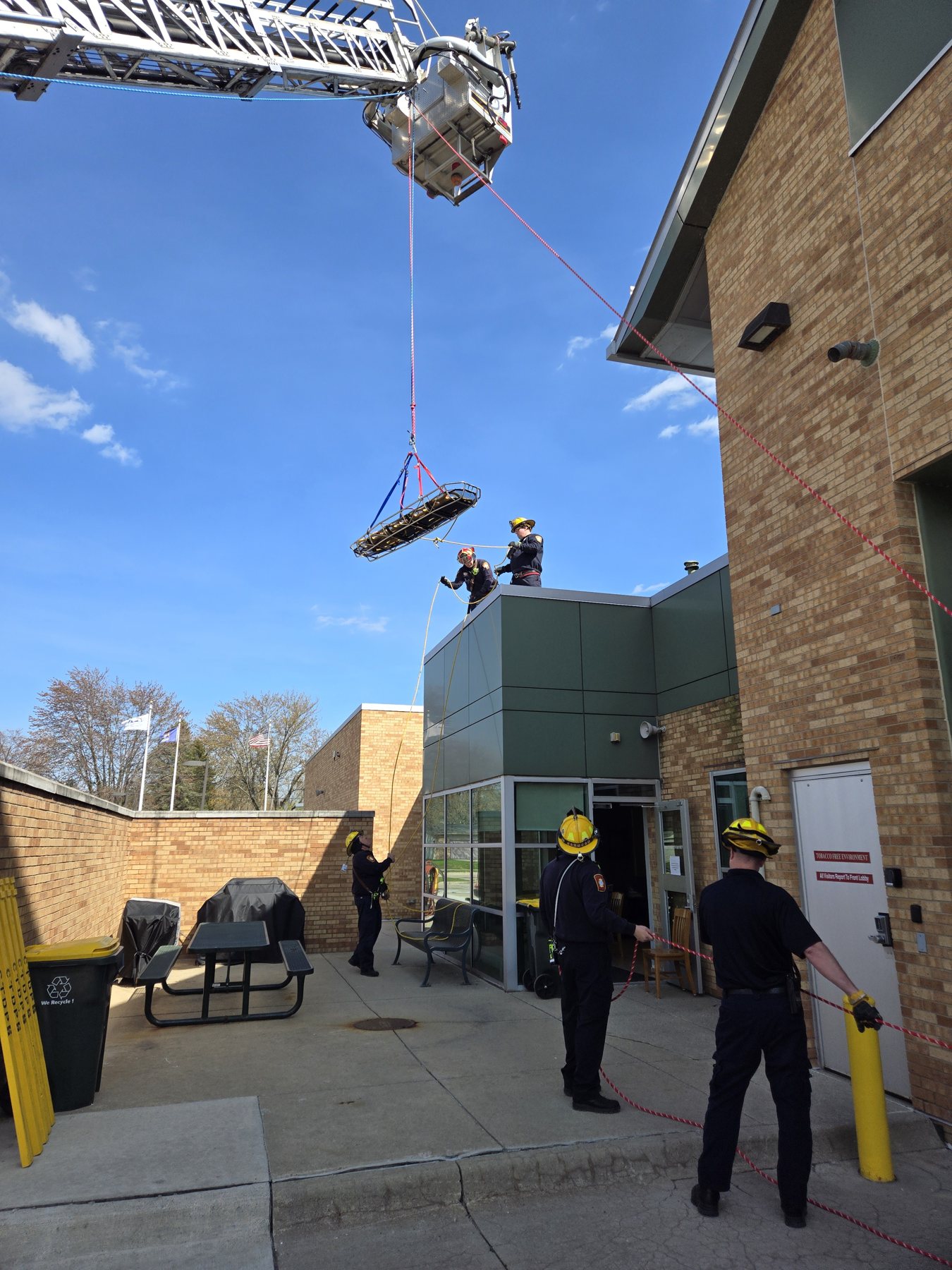 A basket stretcher raised from Truck 3's aerial during rope rescue training