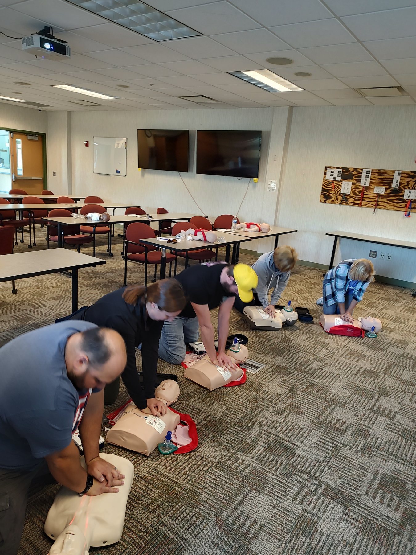 Firefighters and residents practicing CPR on manikins