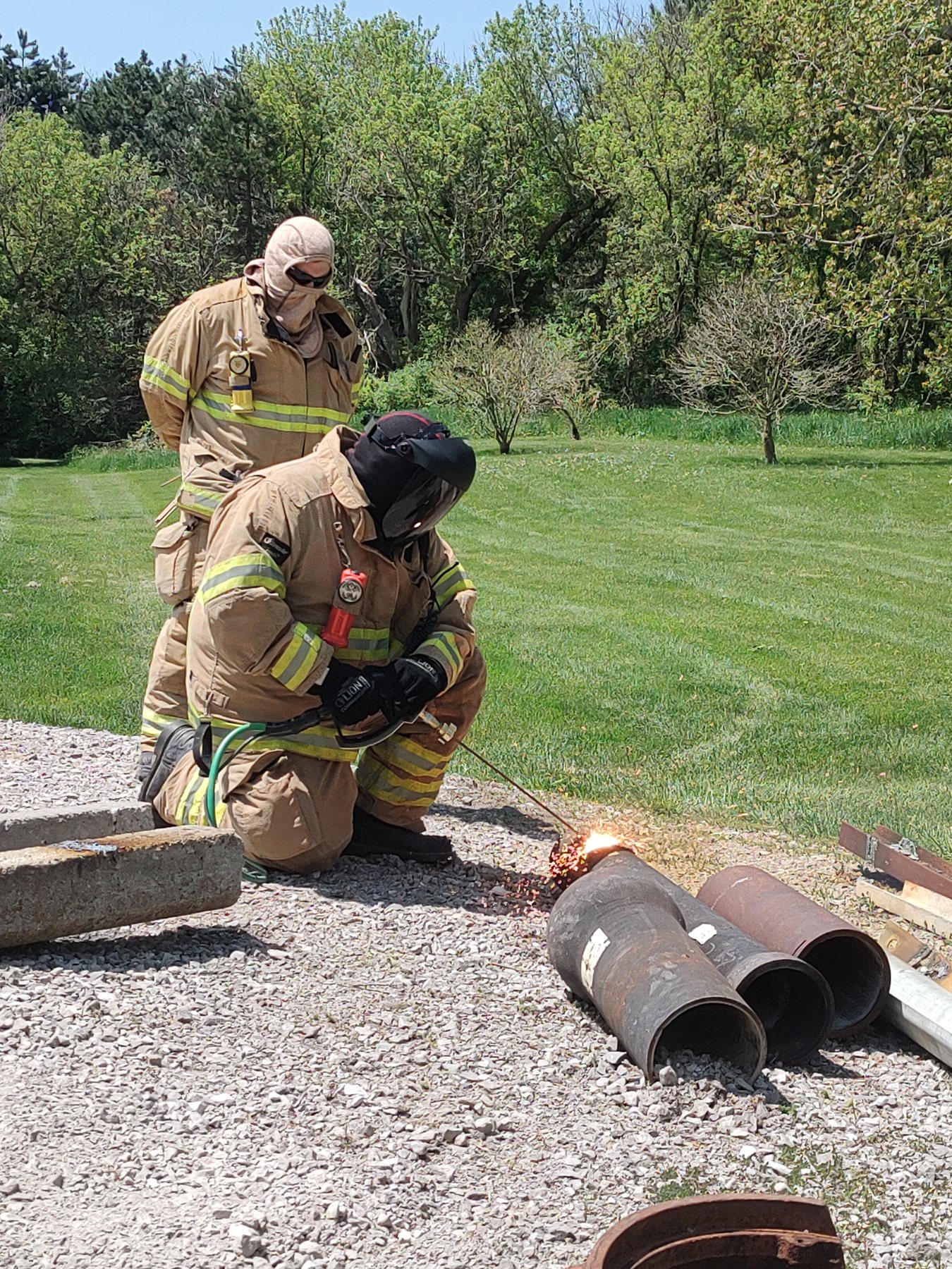 Firefighters in SCBA training with a rotary saw