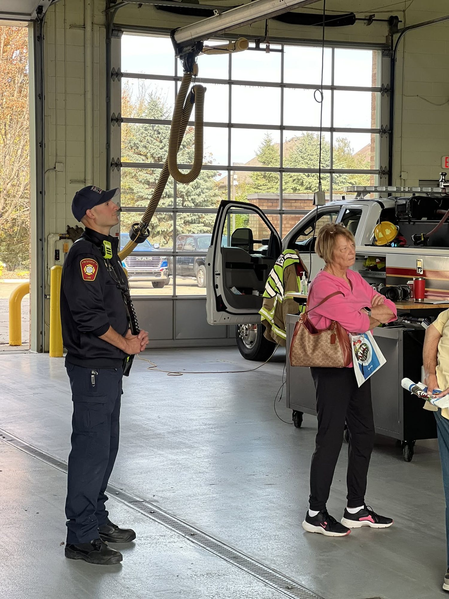 A firefighter talking with a family in the apparatus bay