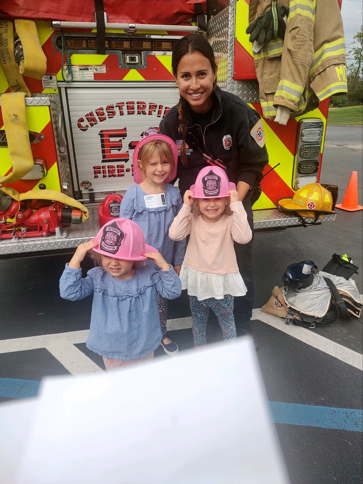 Children in pink fire helmets with a Chesterfield firefighter